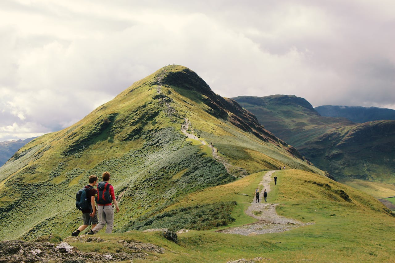 Hikers enjoy a scenic walk along a ridge in the stunning Lake District, England.